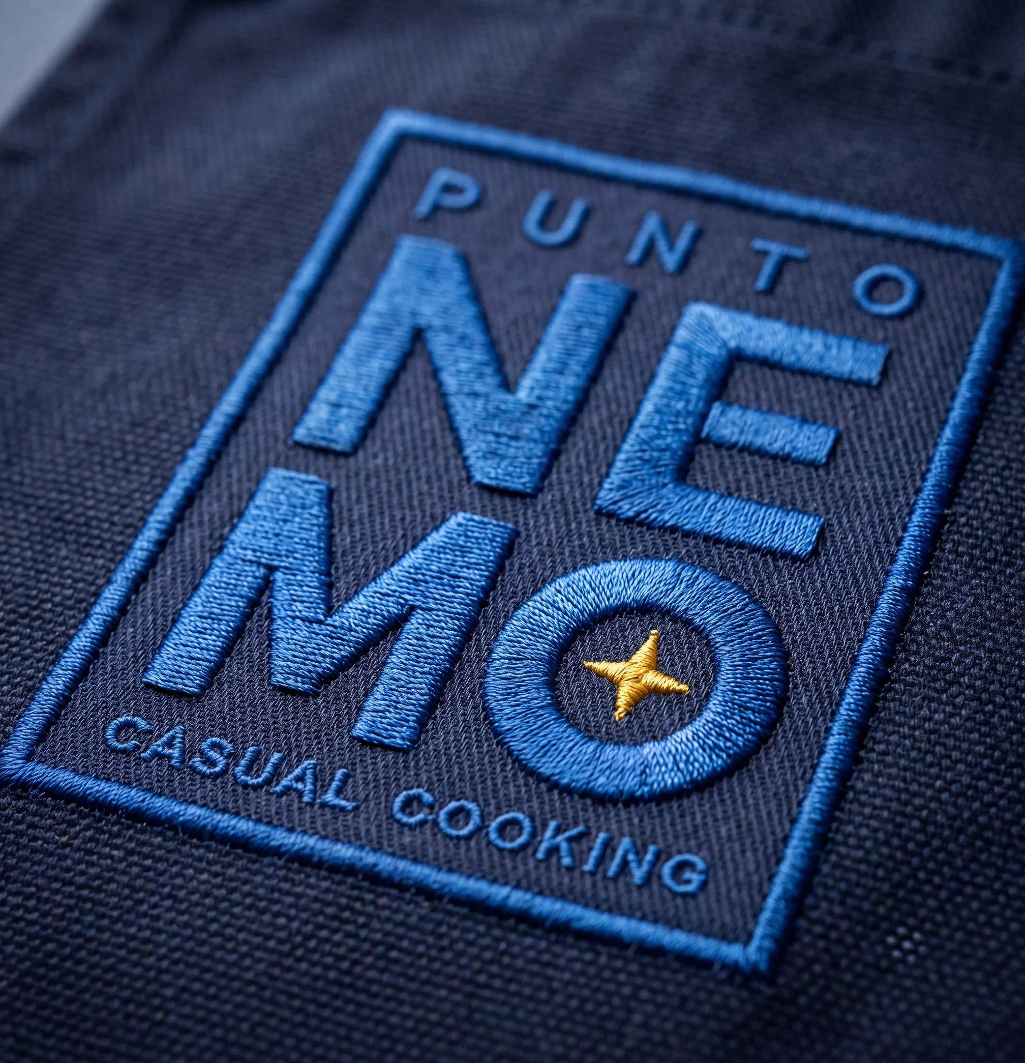Detalle de parche bordado con el logotipo Punto Nemo sobre denim